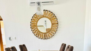 Ein Essbereich mit einem Holztisch, sechs Stühlen und einem dekorativen Spiegel an der Wand.