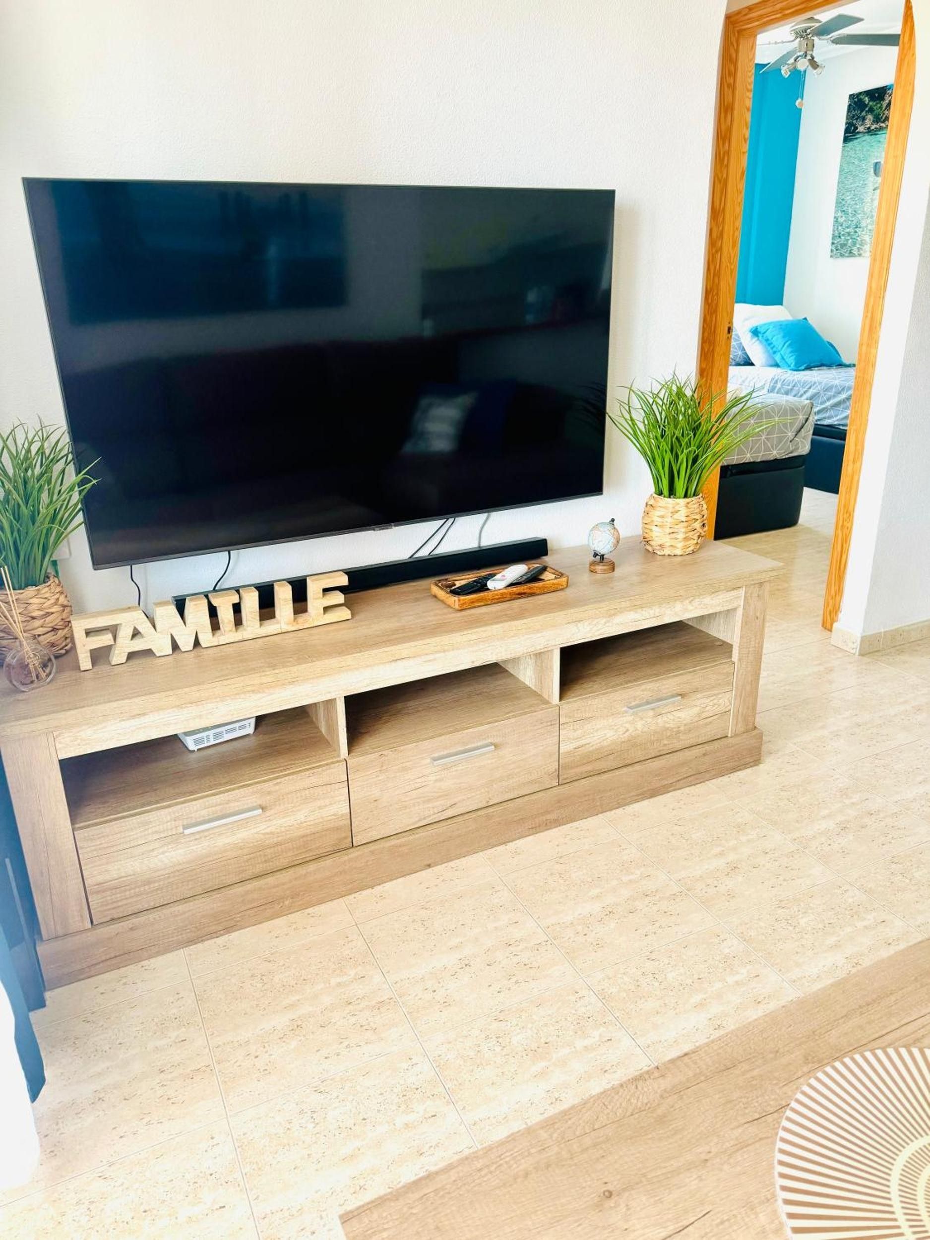 En moderne stue med et fladskærms-tv på et træ-tv-bord med teksten 'FAMILIE'.