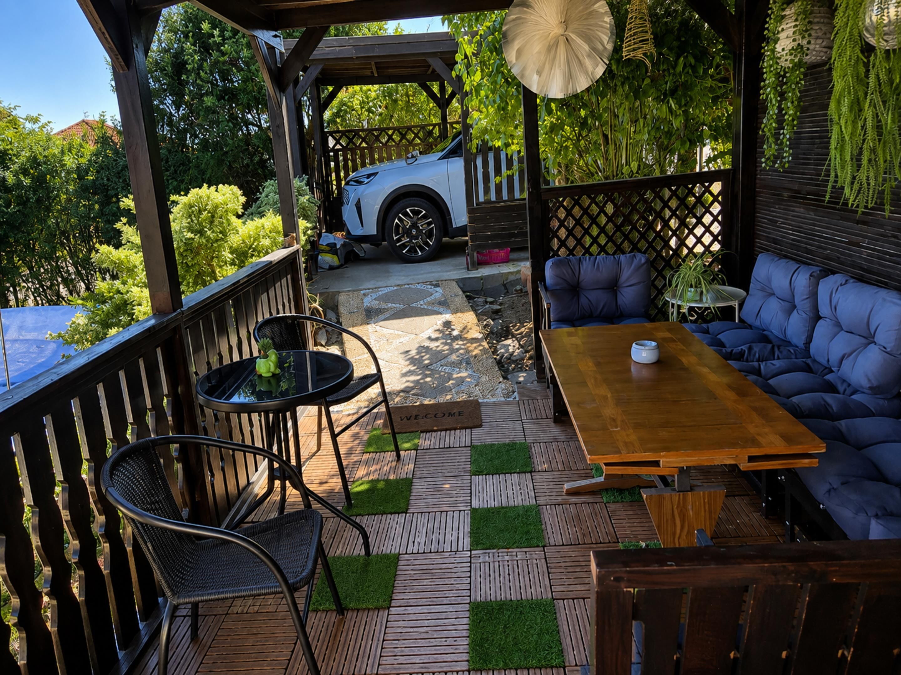 Un patio exterior con terraza de madera, un sofá y una mesa.