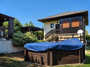 Una casa a due piani con una zona esterna coperta, un'antenna parabolica e un pontile in legno.
