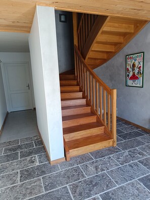 Eine Holztreppe mit Handlauf, die zu einer oberen Etage führt.