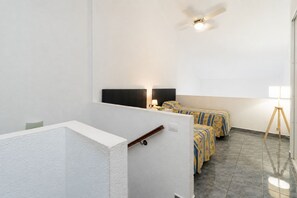 A hotel room with a bed, bedside table, lamp, and a ceiling fan. - Central 1 Bedroom Apartment. Communal Heated Pool (Los Cristianos)