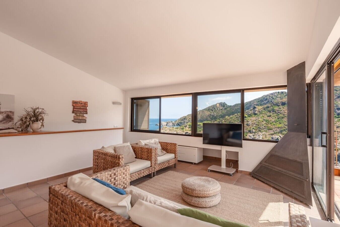A modern living room with a large window, a fireplace, and a television.