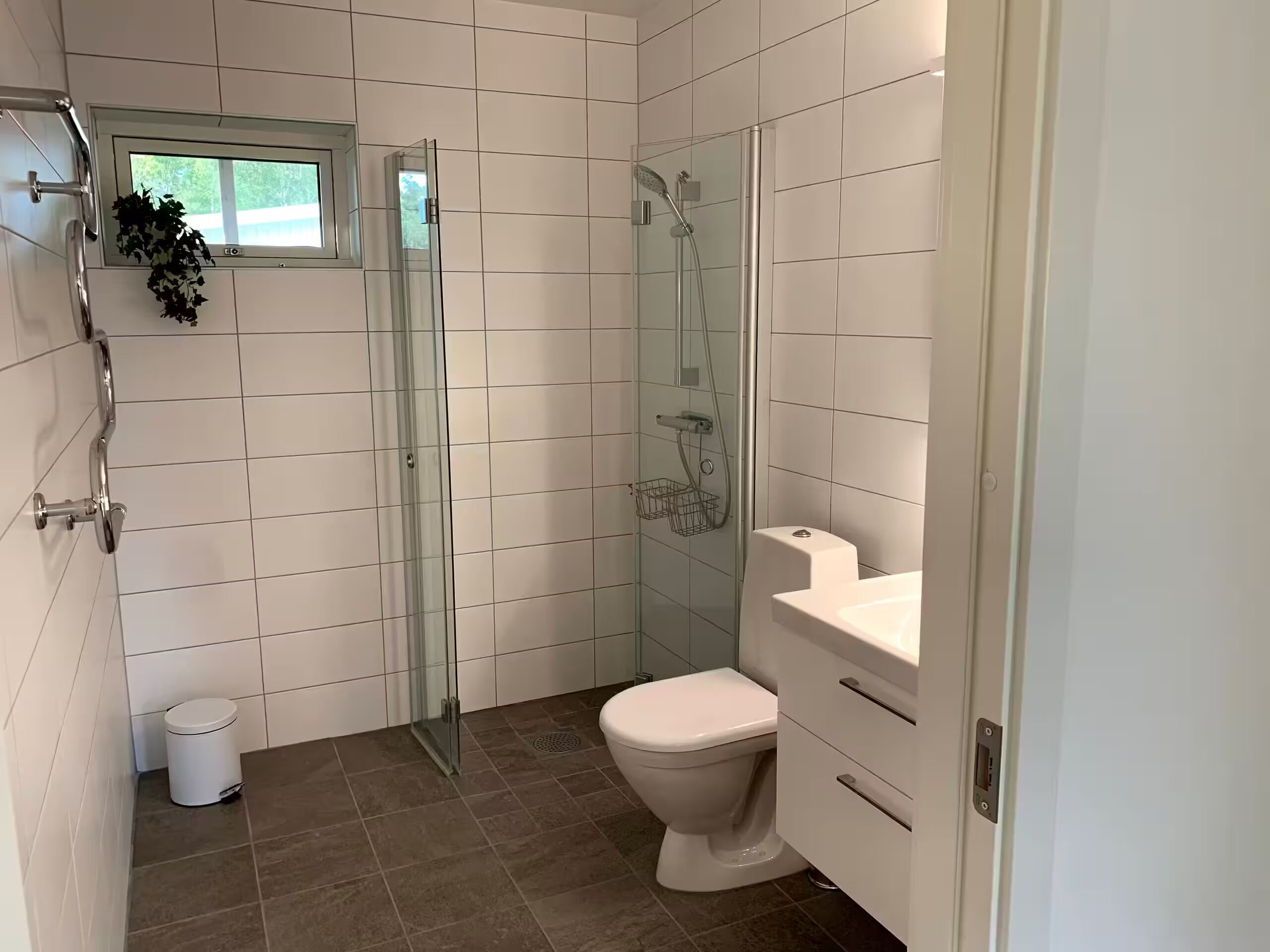 Ein Badezimmer mit Duschkabine, Toilette und Waschbecken.