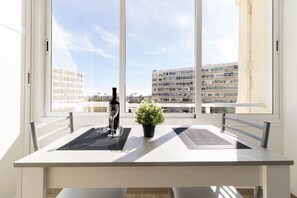 A balcony with a table, a bottle, and a glass, overlooking a residential area. - SEAVIEW estudio: 5 min to Jumbo (Playa del Ingles)