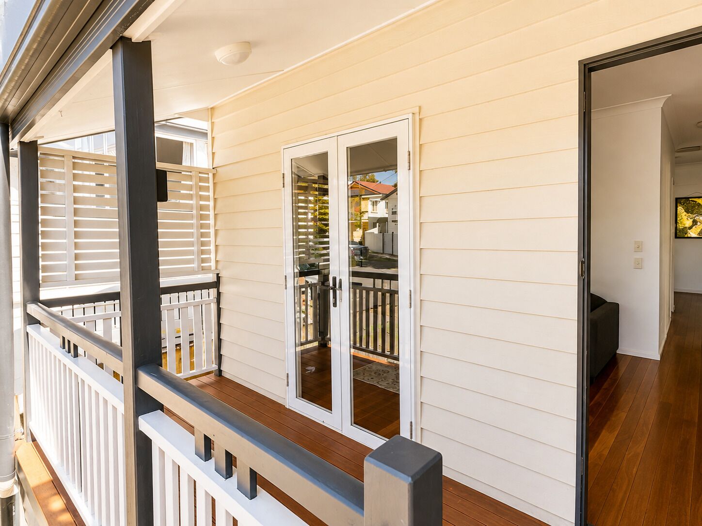 A residential property with a covered porch, a sliding glass door leading to a backyard, and a visible outdoor seating area.
