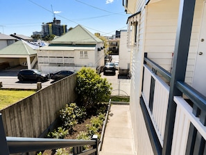 A residential area with a narrow street, houses with sloped roofs, and a wooden fence. - Charming Queenslander 3 bed 1 bath in West End (West End)