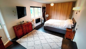 A bedroom with a bed, a dresser, a TV, a window, and a fan. - Cabin Lodge - Sleeps 4 - Country Views - Parking (Tarporley)
