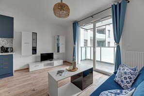 A modern living room with a flat-screen TV, a coffee table, and a sofa with patterned cushions. - Horizon - Gdansk Seaside (Gdańsk)