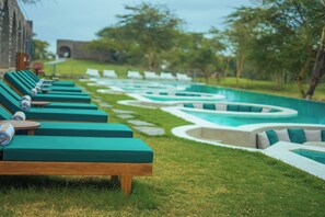 Zona de piscina con sillones de descanso y diseño de pavimento estampado.