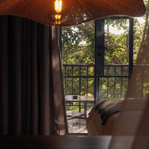 A room with a view of a balcony, a table, and a hanging light fixture. - Giraffe Manor Tanzania (Arusha)