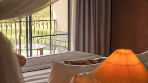 A room with a view of a balcony, a table, and chairs outside. - Giraffe Manor Tanzania (Arusha)