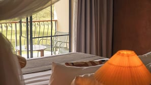 Habitación con vistas a un balcón, una mesa y sillas afuera.