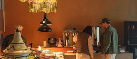 A buffet setup with various food items and a coffee station.