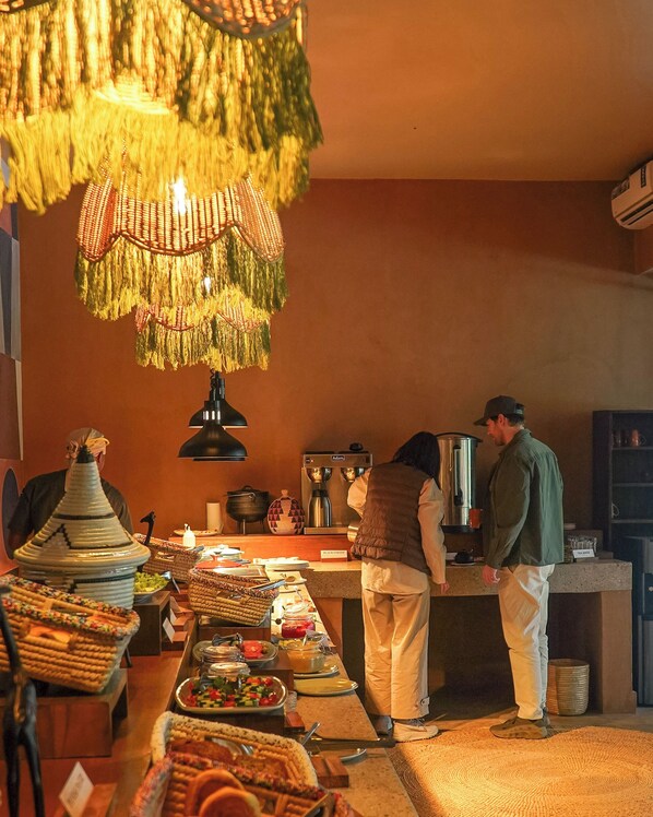 Montaje de bufé con diversos alimentos y una estación de café.
