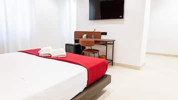 Ein Hotelzimmer mit einem Bett, einem Schreibtisch und einem Fernseher.