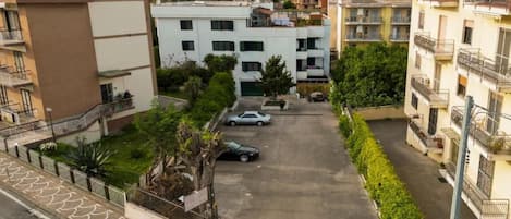 Zona residencial con edificios de varios pisos, un estacionamiento y una montaña al fondo.