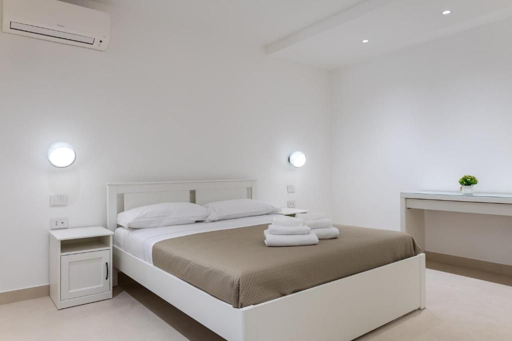 A modern bedroom with a single bed, bedside tables, a small cabinet, and a desk with a plant.