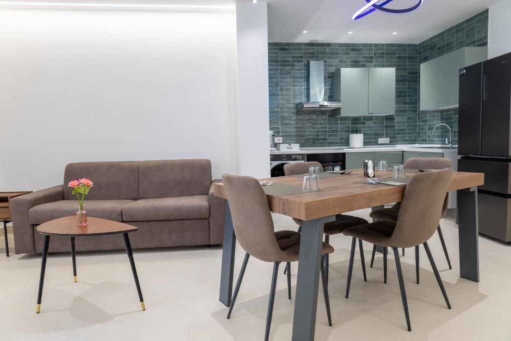 Una cocina moderna con comedor, que incluye un sofá, una mesa de madera y sillas.