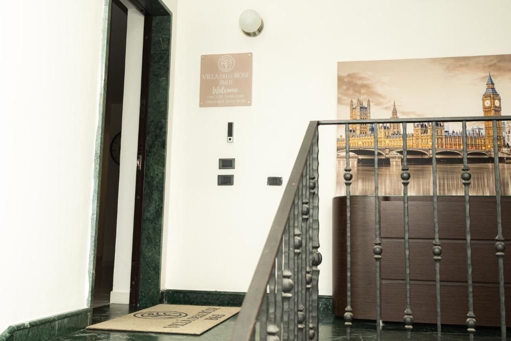 A hotel reception area with a signboard, a staircase, and a view of a cityscape.