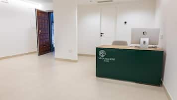 Una reception con un logo, una porta e un corridoio.