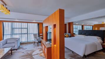 Una habitación de hotel moderna con una cama grande, un escritorio, una silla y un sofá.
