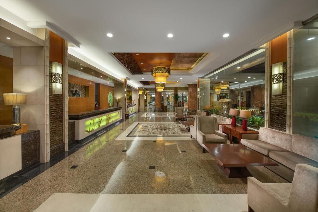 A hotel lobby with a reception desk, seating area, and a view of the lobby in the background.