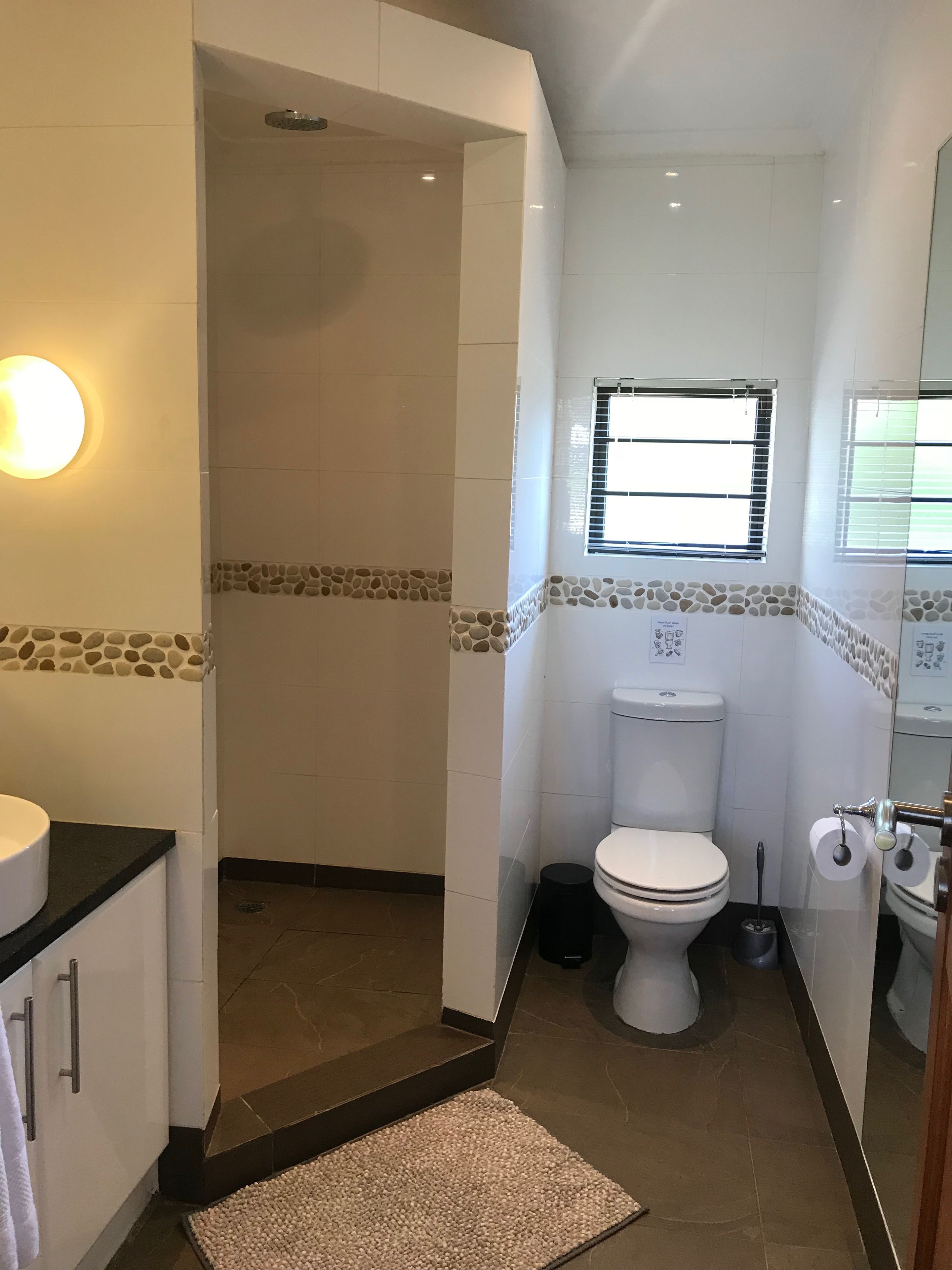 A bathroom with a shower, toilet, and sink.