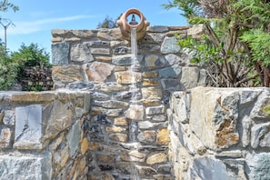 A stone structure with a water spout. - Apartment 'Bilocale Dolores' with Shared Pool, Wi-Fi and Air Conditioning (Campo nell'Elba)