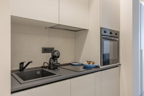 A modern kitchen with a built-in oven, a coffee machine, and a sink. - Apartment 'Calcagno Home 3' with Private Terrace, Wi-Fi and Air Conditioning (Milazzo)