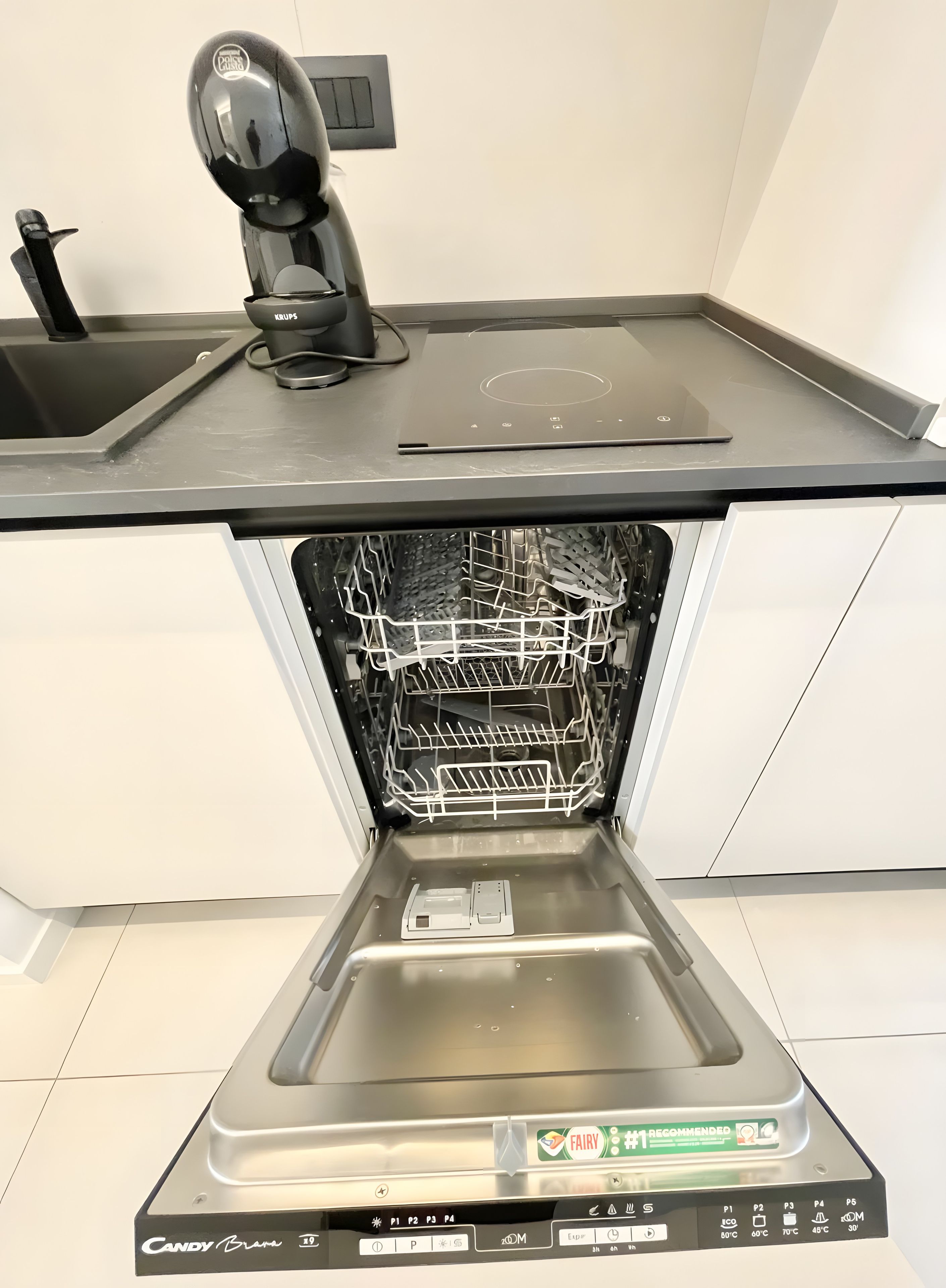 A kitchen with a built-in dishwasher, a sink, and a countertop.