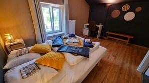 Een slaapkamer met een bed, nachtkastjes, een bureau en een bank.