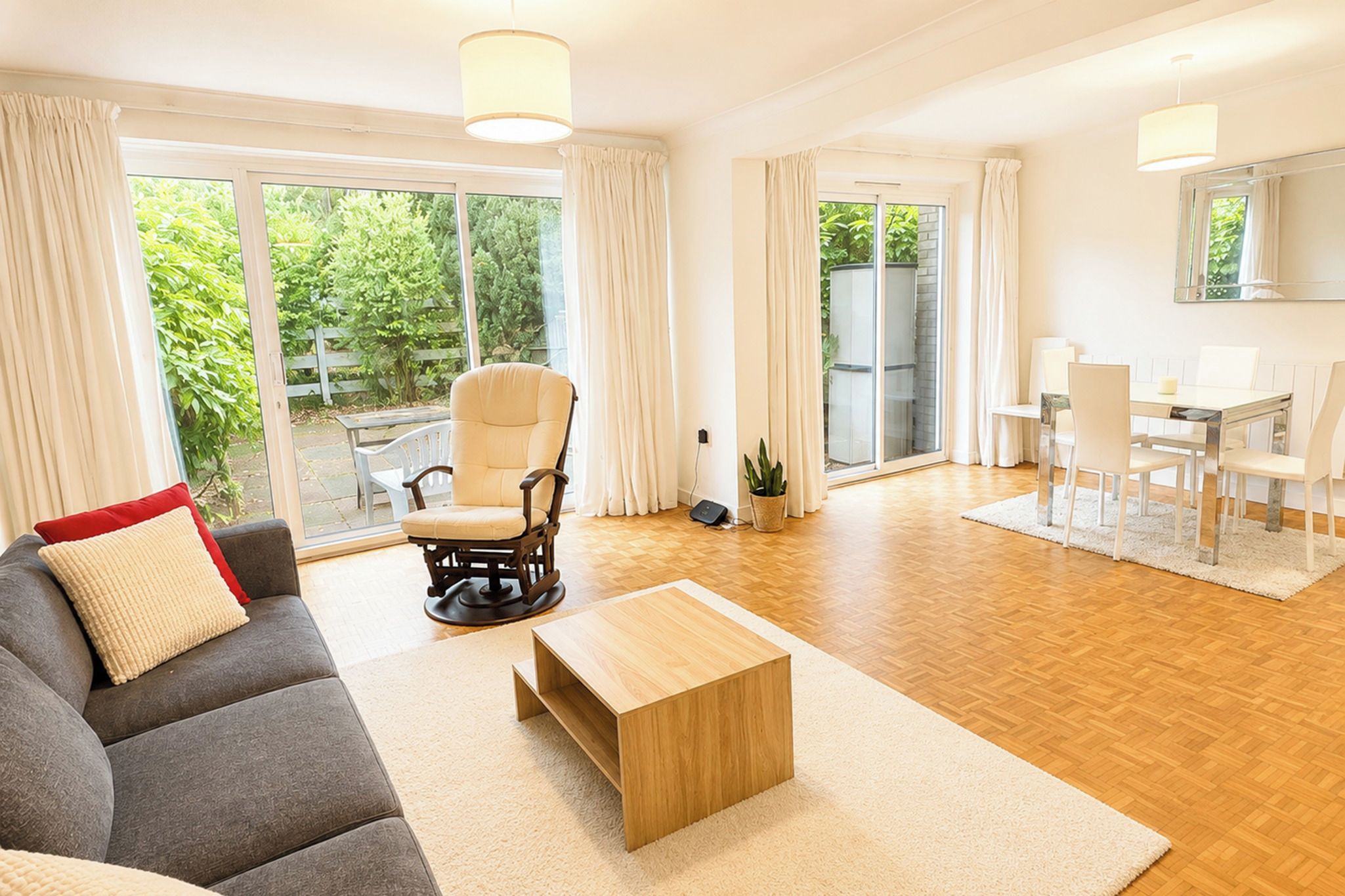 Un vaste espace de vie comprenant un canapé, une table basse en bois et une table à manger avec des chaises.