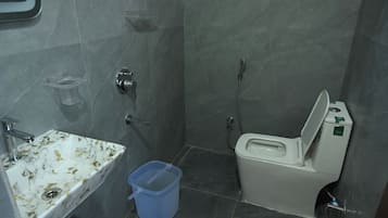 Un bagno piccolo con il water, un lavandino e una doccia.