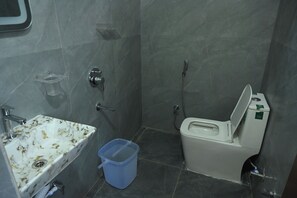 Un baño pequeño con inodoro, lavamanos y ducha.