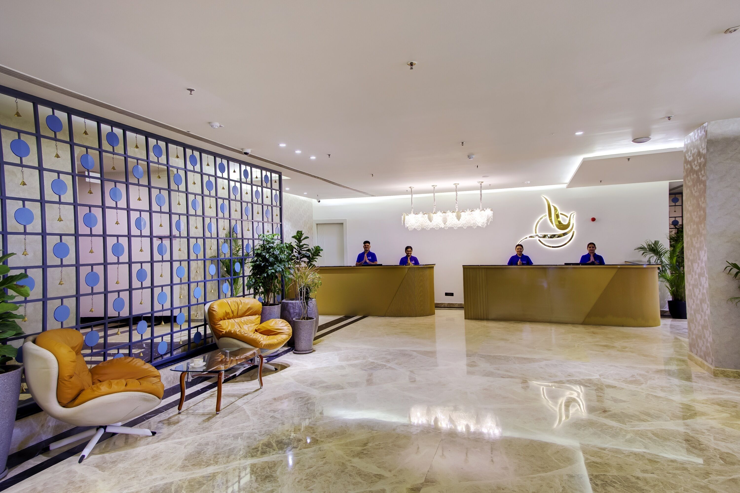 A hotel reception area with a modern design, featuring a reception desk, seating area, and decorative elements.