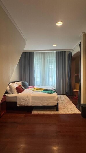 A bedroom with a bed, a nightstand, a window with curtains, and a ceiling light. - Nueng Rana 149 | A Unique Stay Experience | BKK - Holiday Home (Samphanthawong)