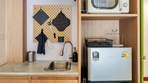 A compact kitchen with a microwave, toaster, and sink. - Nueng Rana 149 | A Unique Stay Experience | BKK - Holiday Home (Samphanthawong)