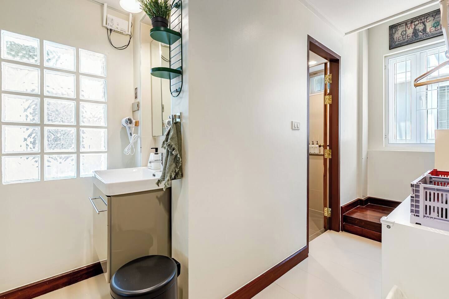 Ein Badezimmer mit Toilette, Waschbecken, Handtuchhalter und einer Zimmerpflanze.