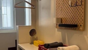 A kitchen with built-in shelves, a pegboard with hooks, and a window with blinds. - Nueng Rana 149 | A Unique Stay Experience | BKK - Holiday Home (Samphanthawong)