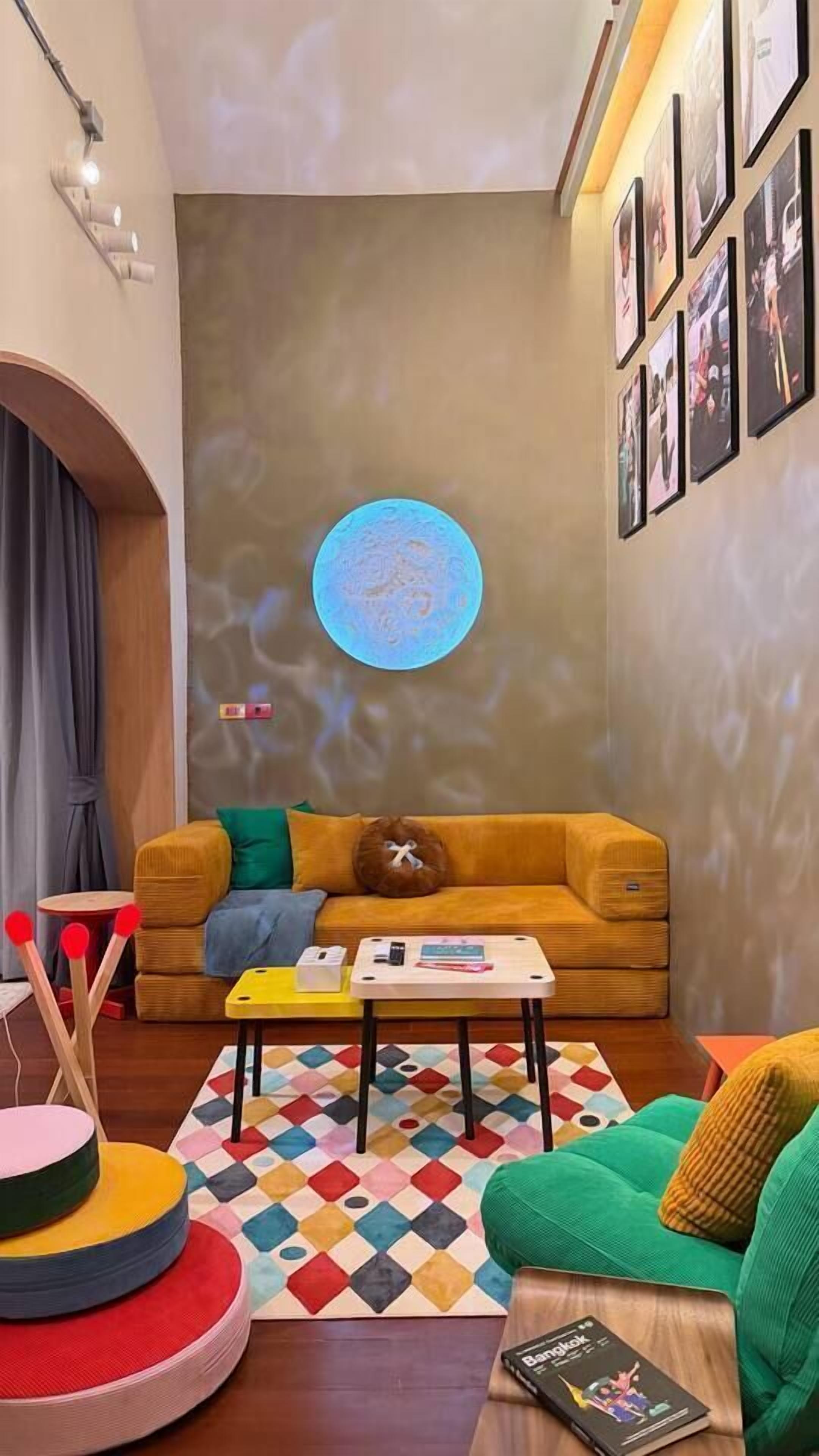 Ein gemütliches Wohnzimmer mit einer Couch, einem Couchtisch und einem bunten Teppich.