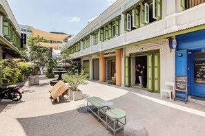 Un patio con mobiliario exterior, una fuente y un bar.