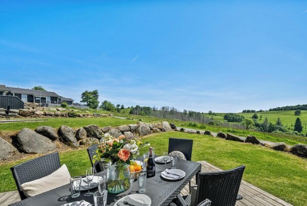An outdoor dining area with a view of a house and rolling hills. - Holiday Home With 1 Bedroom (Braunlage)