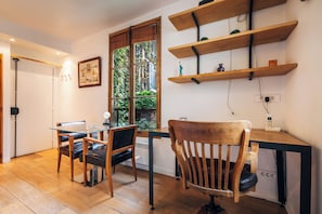 A modern kitchen with wooden flooring, a glass dining table, and a wooden chair. - luxury 1BR quiet fully equipped kitchen washer/drier (Paris)