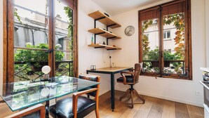 Una cocina moderna con una mesa de comedor de vidrio, sillas de madera y una estantería empotrada.