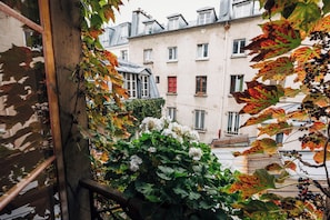 A balcony with a view of a building with multiple windows and balconies. - luxury 1BR quiet fully equipped kitchen washer/drier (Paris)