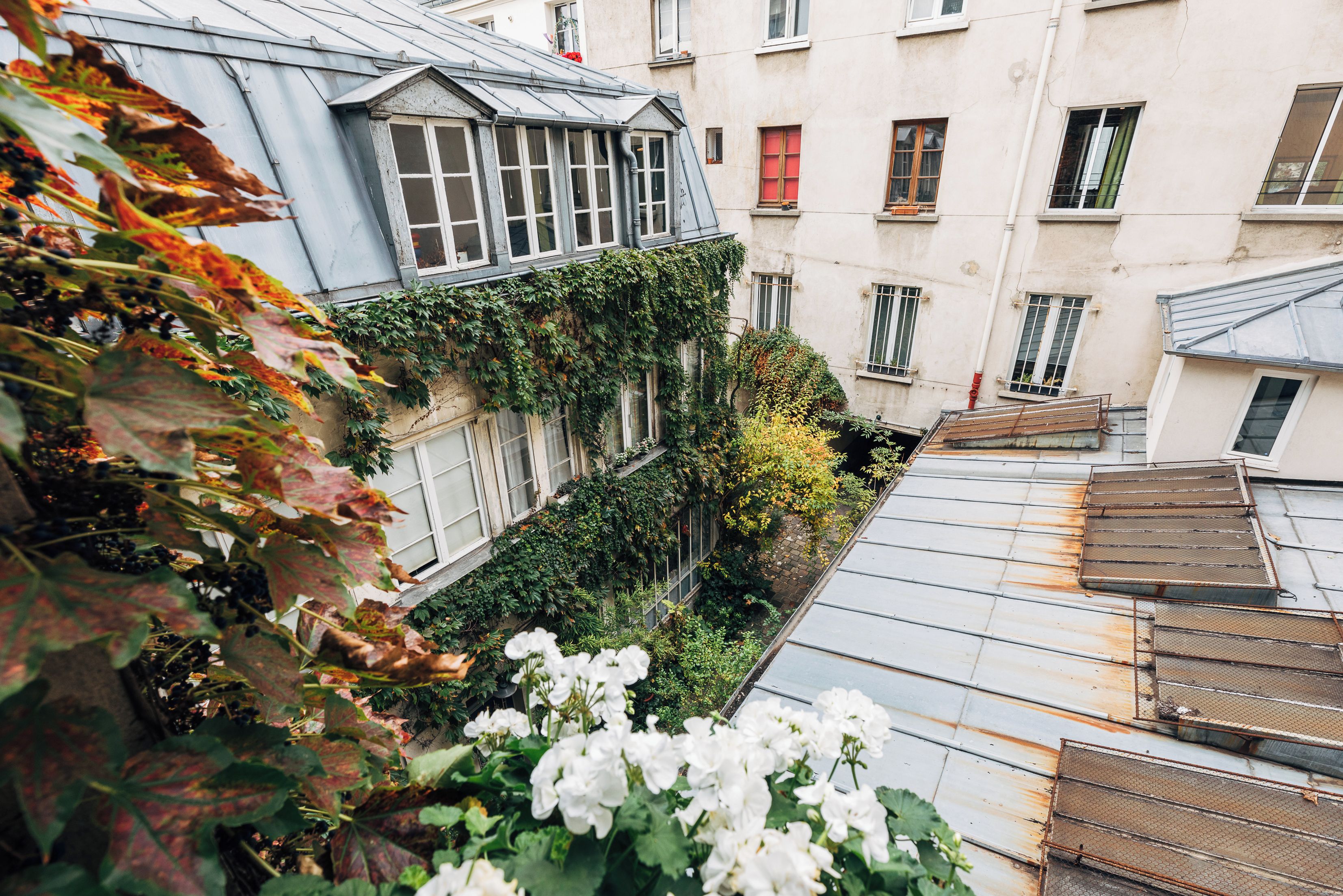 Une rue étroite bordée de bâtiments des deux côtés, où se côtoient des immeubles d’habitation et des locaux commerciaux.