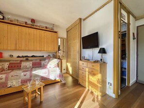 A cozy room with a bed, wooden furniture, a television, and a small table. - (SO.317) Alpine-style studio, right at the slopes, Les (Les Menuires)