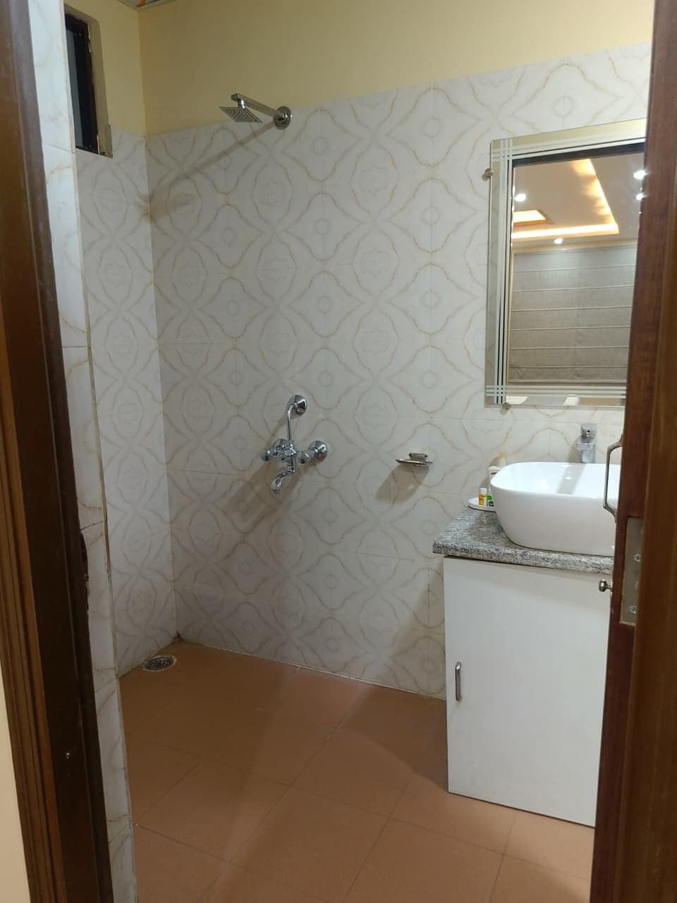 A bathroom with a shower, a sink, and a mirror.