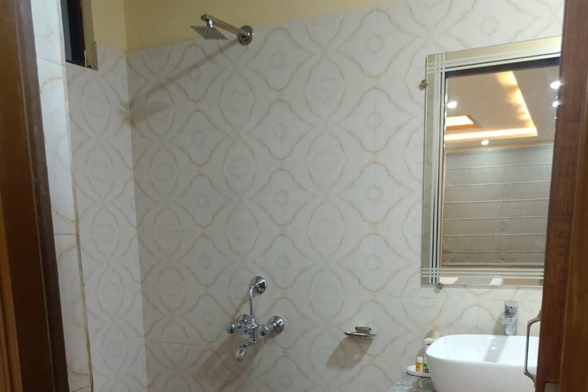 Un baño con ducha, lavabo y espejo.